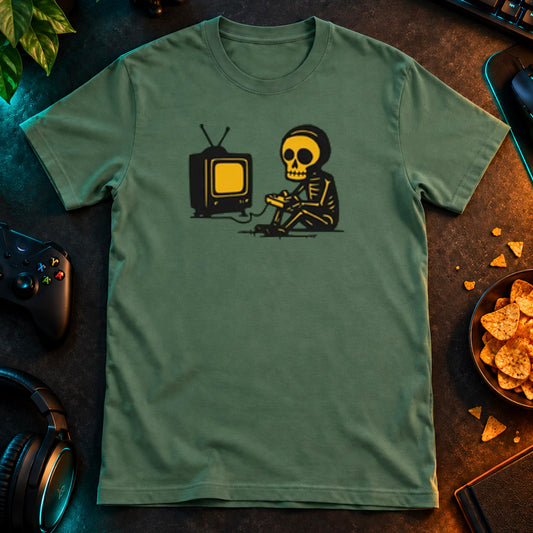 T-shirt featuring a skeleton using a game controller in front of a television.