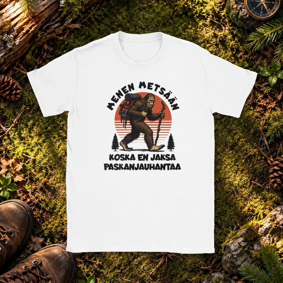 T-shirt featuring a gorilla hiker with a backpack and stick beside the Finnish words Menen mets��n.
