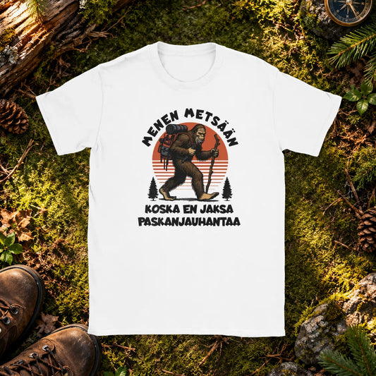 T-paita, jonka printissä gorillaretkeilijä rinkan ja sauvan kanssa sekä Menen metsään -teksti.