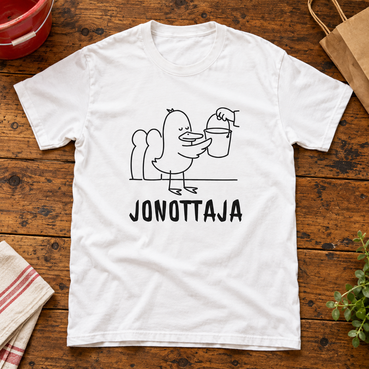 Themed flat-lay photograph of Ämpärijonon Sankari - T-paita with accessories related to its printed design.