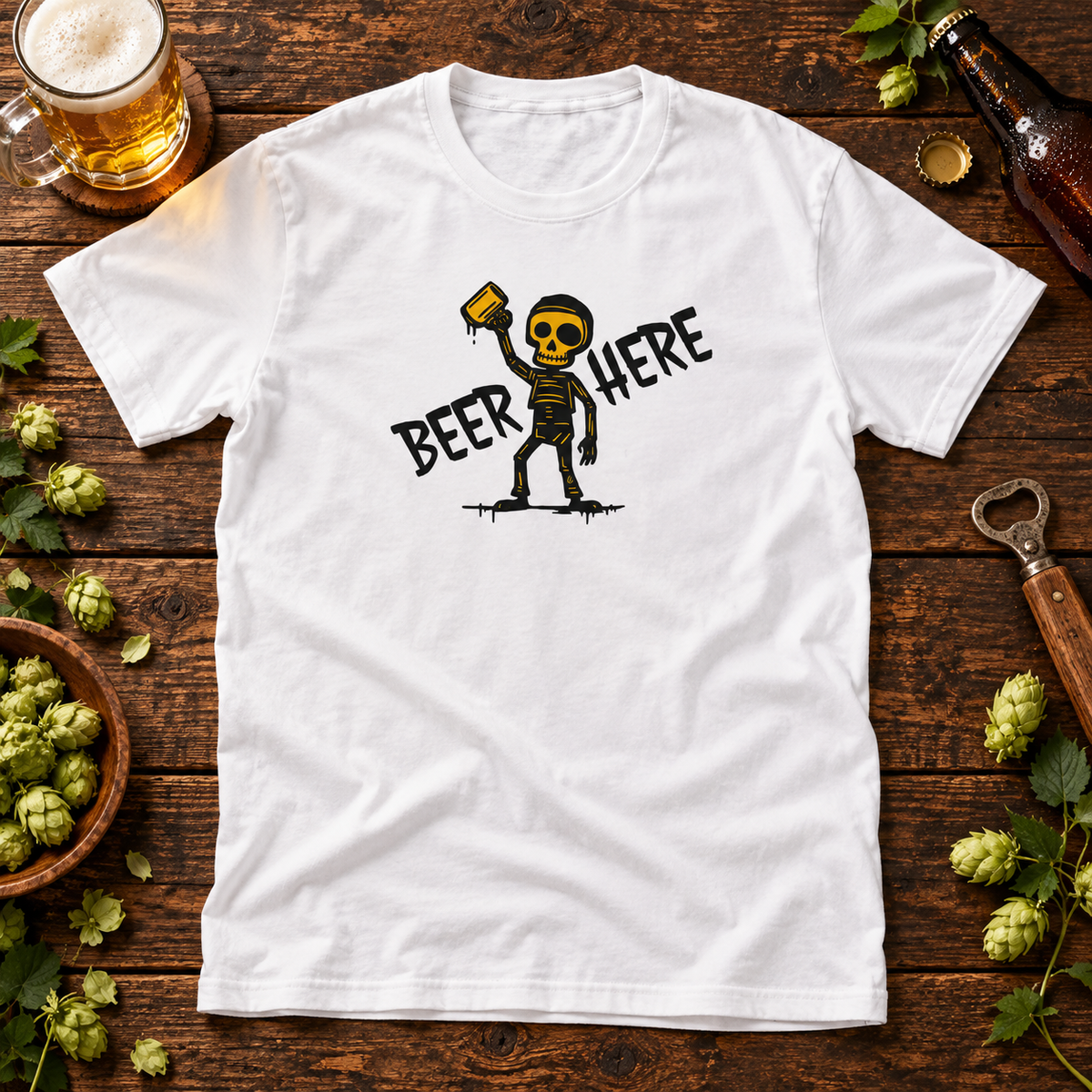 White Beer Here skeleton T-shirt on a wooden table with beer themed props.