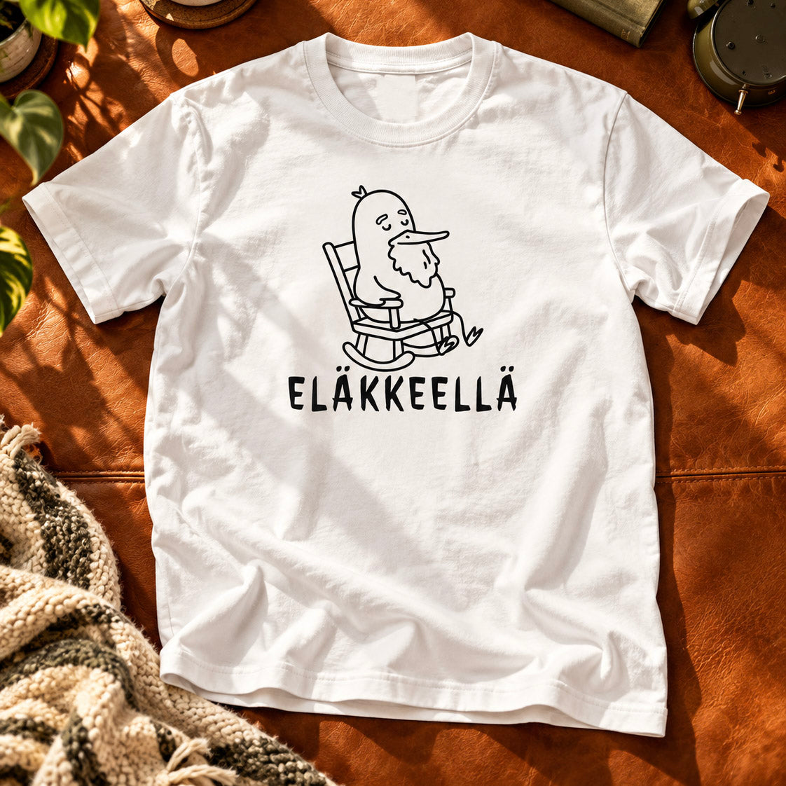 T-shirt featuring a bearded duck in a rocking chair beside the Finnish word EL�KKEELL�.