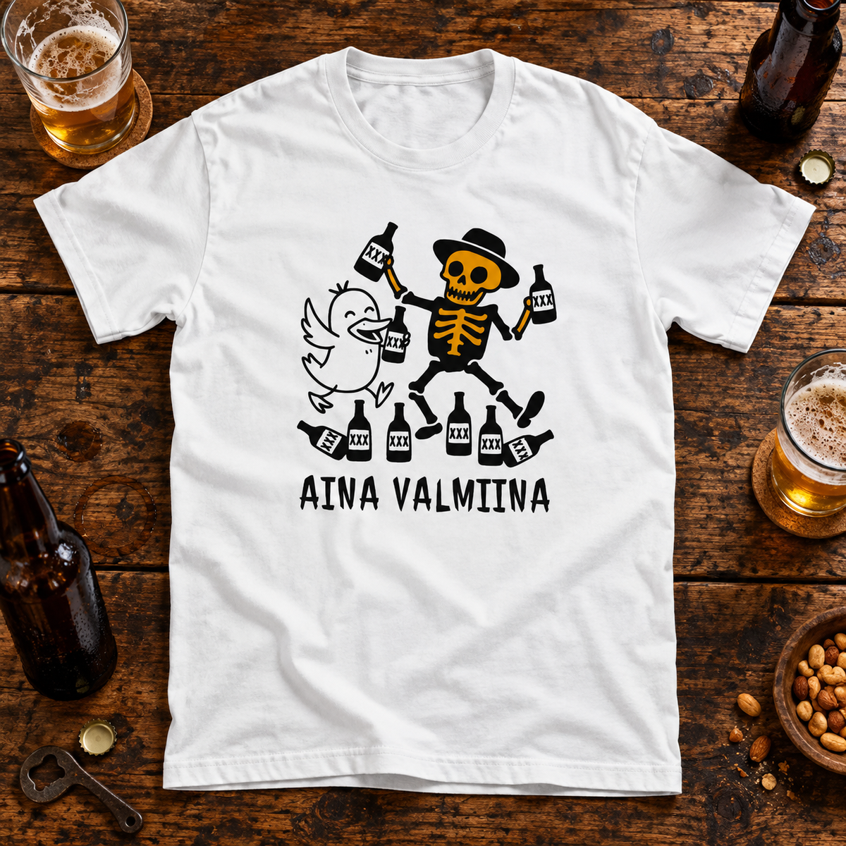 Valkoinen t-paita, jonka printissä ankka ja luuranko pullojen kanssa sekä AINA VALMIINA -teksti. Printin aiheeseen liittyvä tuotekuva ja rekvisiitta.
