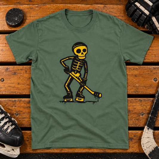 Military green Lätkäjätkä skeleton hockey T-shirt on a wooden locker room bench with a puck, skates and hockey gloves.