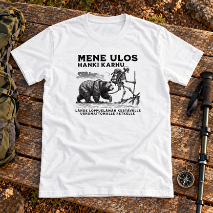 Valkoinen t-paita, jonka printissä luurankoretkeilijä ja suuri karhu metsässä. Printin aiheeseen liittyvä tuotekuva ja rekvisiitta.