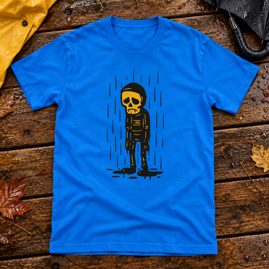 Royal blue Sateeseen sad skeleton T-shirt on a rainy porch table with umbrella and raincoat.