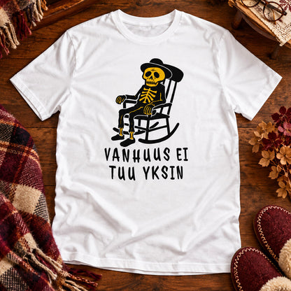 T-shirt featuring a skeleton in a rocking chair beside the Finnish words VANHUUS EI TUU YKSIN.