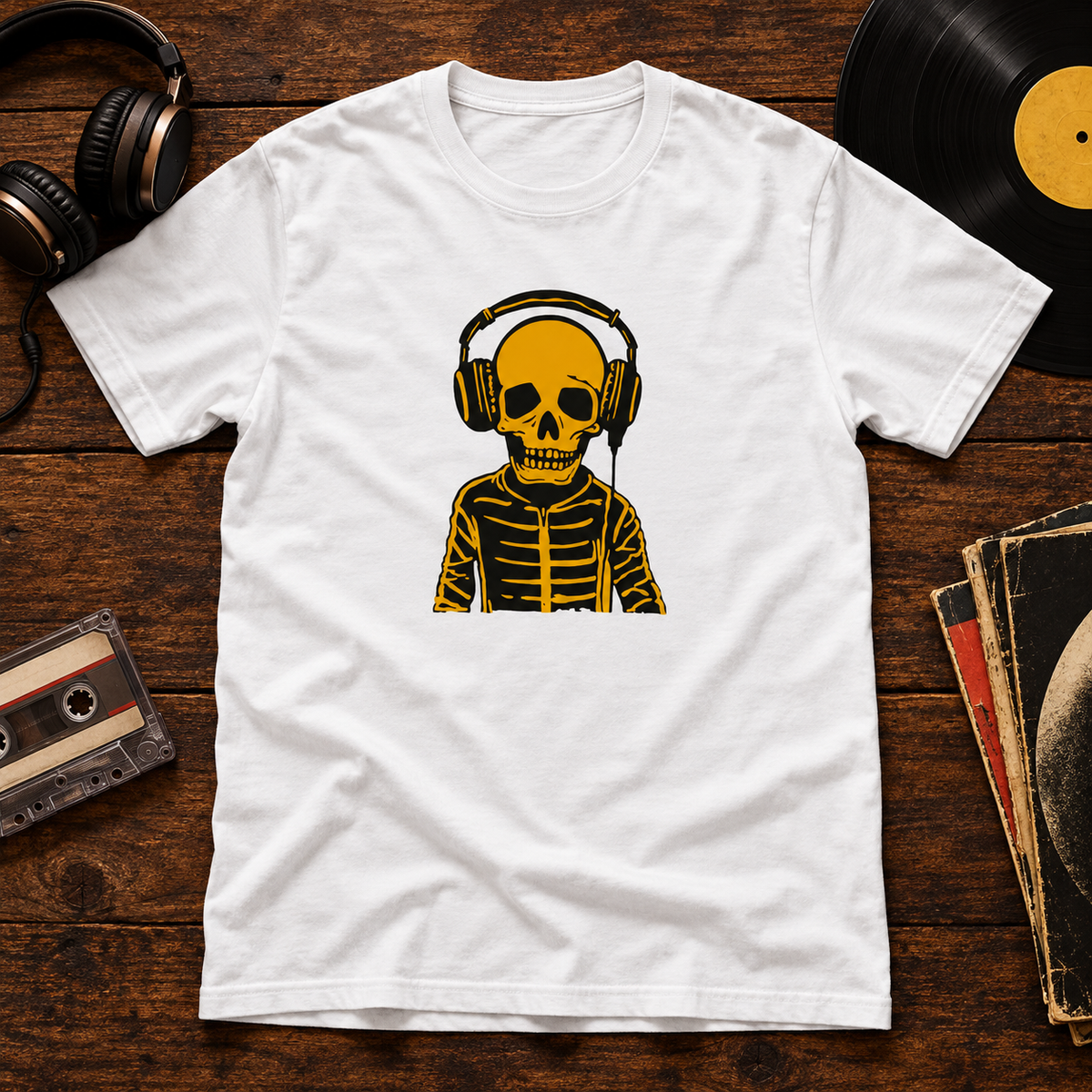 Valkoinen t-paita, jonka printissä luurankohahmo kuulokkeet päässä. Printin aiheeseen liittyvä tuotekuva ja rekvisiitta.
