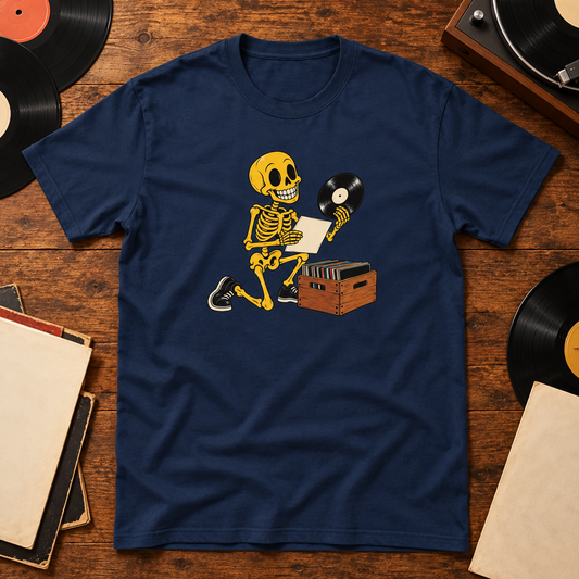 Navy T-shirt featuring a skeleton inspecting a vinyl record beside a crate of records, on a wooden surface with themed props.