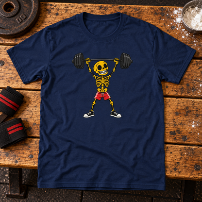 Navy T-shirt featuring a skeleton lifting a barbell in red shorts, on a wooden surface with themed props.